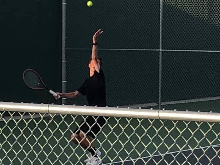 Front Range Academy player reaching high for a serve