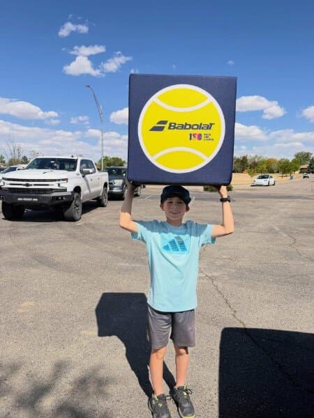 Dash holding up a Babolat sign